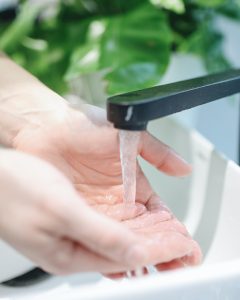 Washing hands in a sink. Water softener advantages.